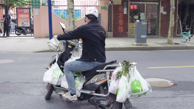 街道上快递小哥在送菜