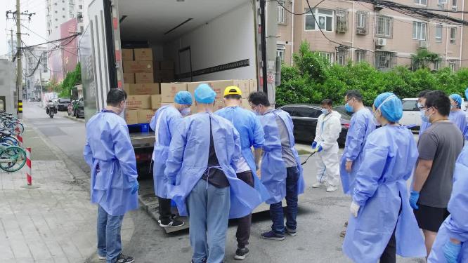 新冠疫情身穿防护服的志愿者为保供物资卸车