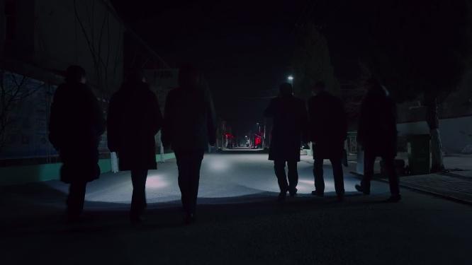 夜晚工作人员走过农村小路