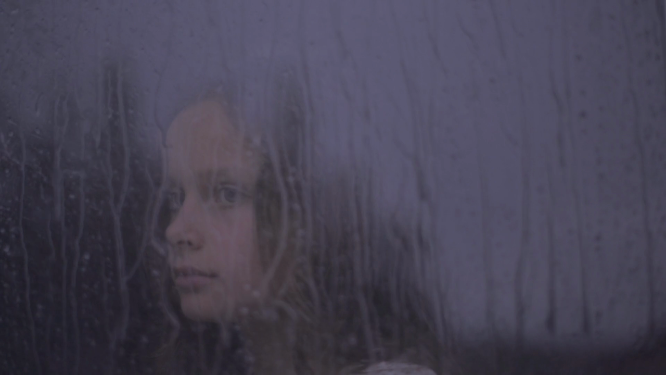女孩在下雨的窗前