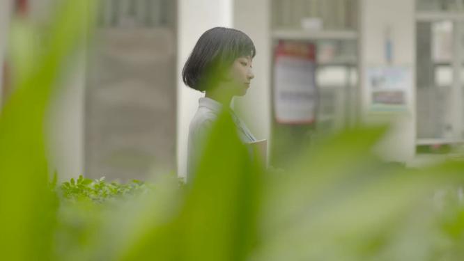 校园中学生抱书行走