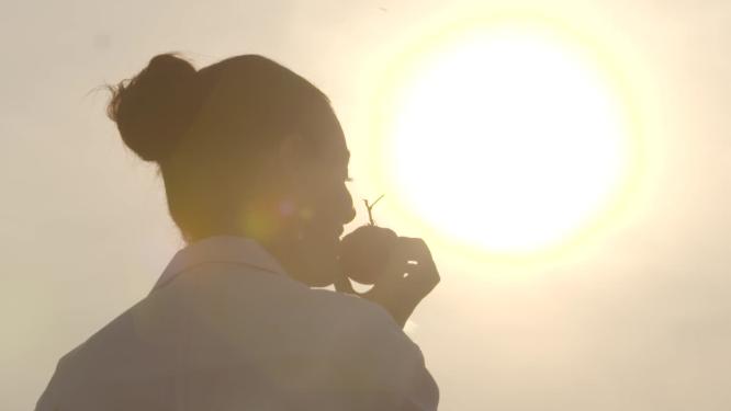 逆光下美女闻蕃茄