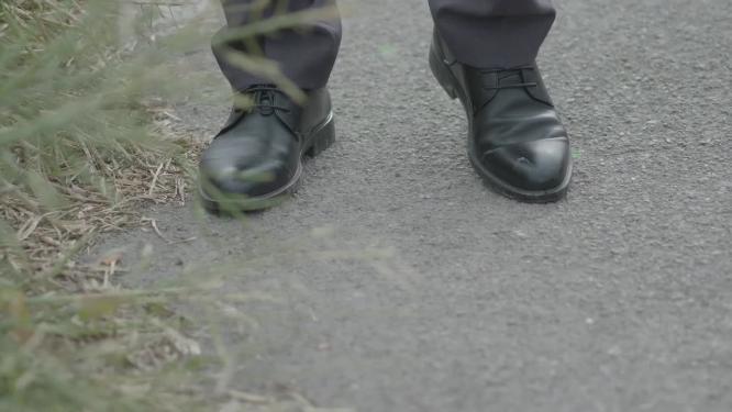 皮鞋踩在泥路上