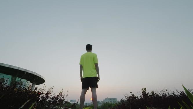 站在高处拥抱清晨阳光的背影