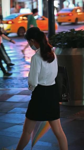 夜晚街头拿雨伞走过的女性 竖屏