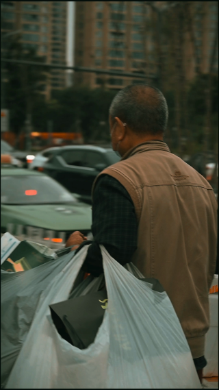 城市街道上手提废品的男性 竖屏