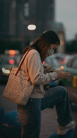 年轻女性站在街边玩手机 竖屏