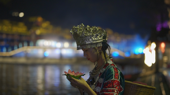 少数民族少女放花灯自然人文风光