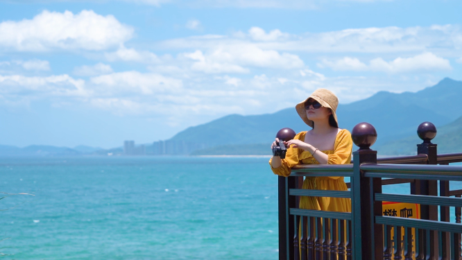美女游客摄影师在石梅湾看台摄影拍摄