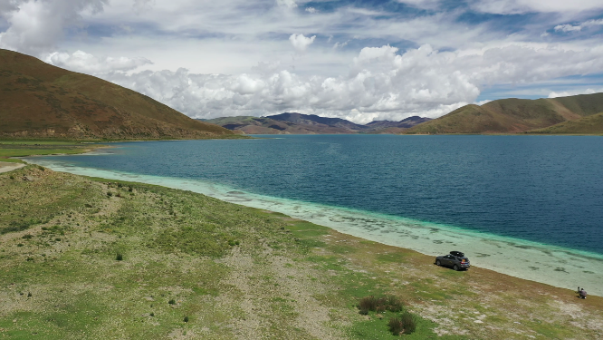 一辆汽车停在西藏羊卓雍措湖泊旁