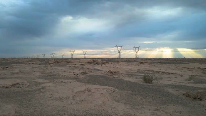 河西走廊甘肃酒泉瓜州沙漠中耶稣光下的西电东送高压塔架 