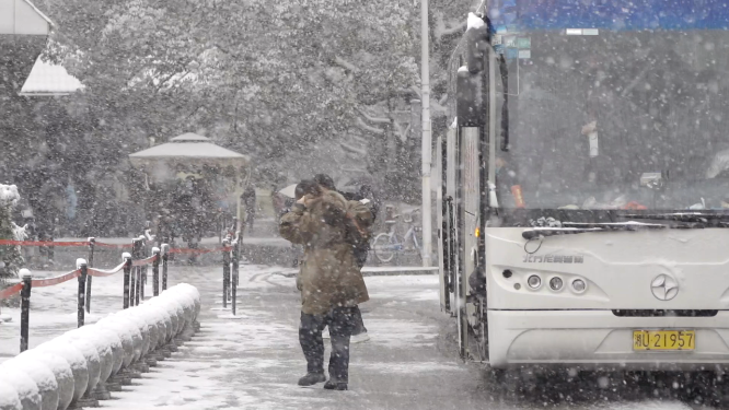 下雪旅游团游客下大巴车 