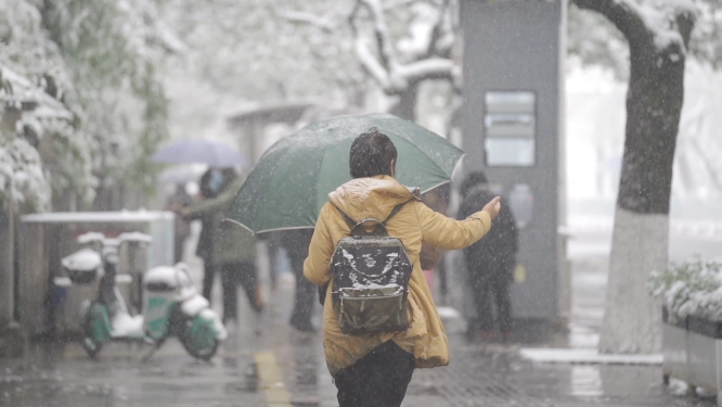 冰雪天气公交站等车的乘客 