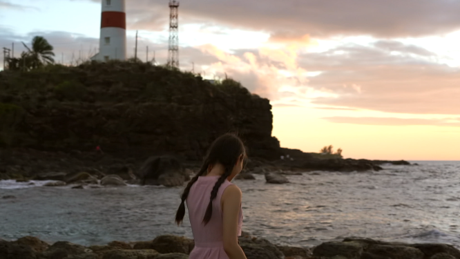女孩独自在海边吹风看夕阳