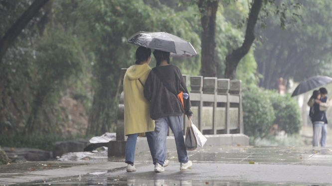 闺蜜雨中挽手散步 