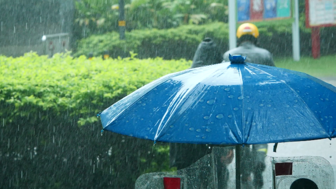 外卖小哥在雨中行走背影