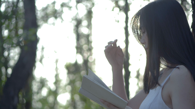 逆光唯美清新树林女孩看书4k视频素材