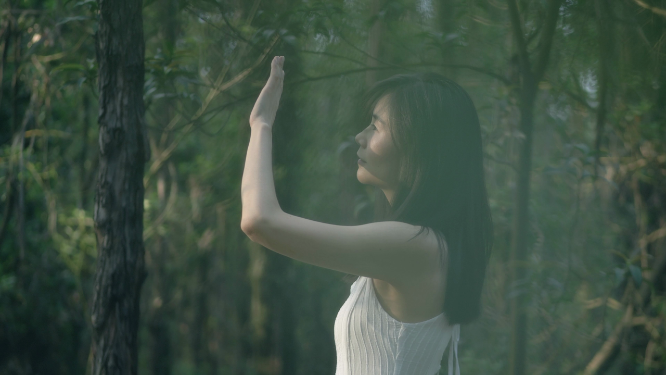 女孩在森林中感受指缝阳光视频素材