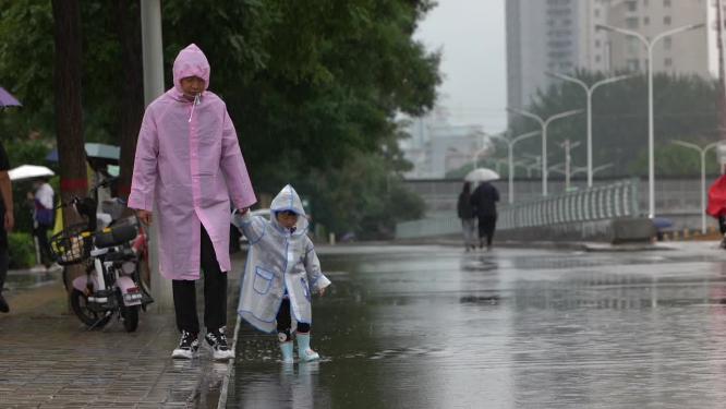父子牵手行走在雨中