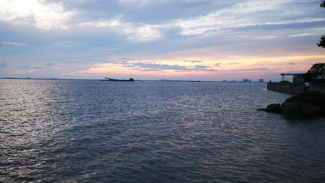 实拍夕阳下大海游船划过