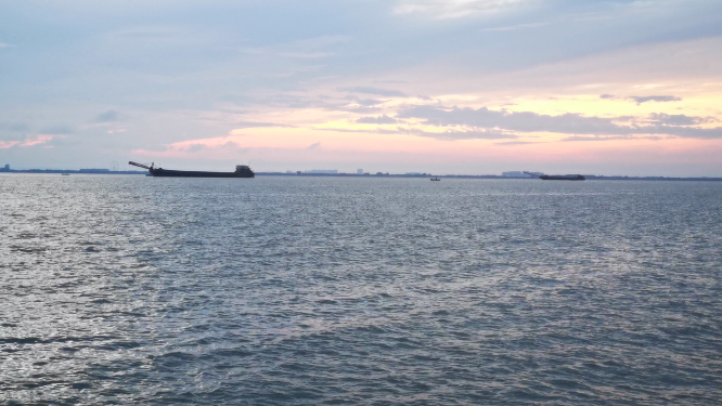 实拍夕阳下大海游船划过
