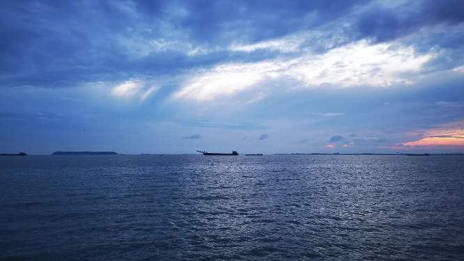 实拍夕阳下大海游船划过