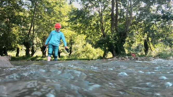 勘探建设工人涉水过小溪