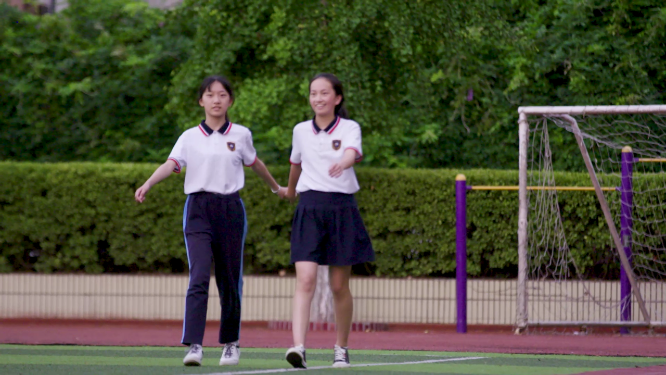 校园女学生悠闲操场散步