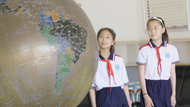 校园地球仪前学生学习交流