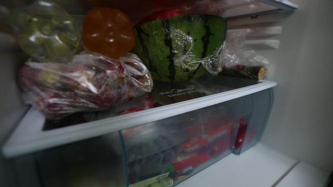 冰箱里隔板上塞满各种食材