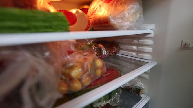 冰箱里隔板上塞满各种食材