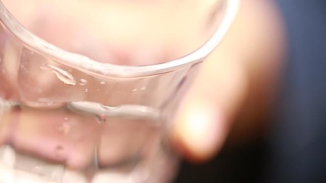 倾倒玻璃杯里的清水白酒