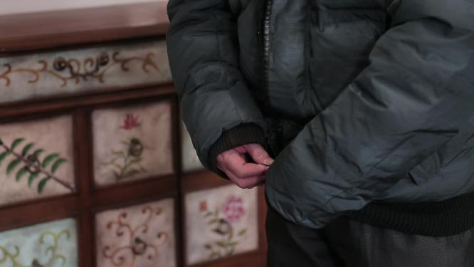 冬季老人穿羽绒服拉拉链