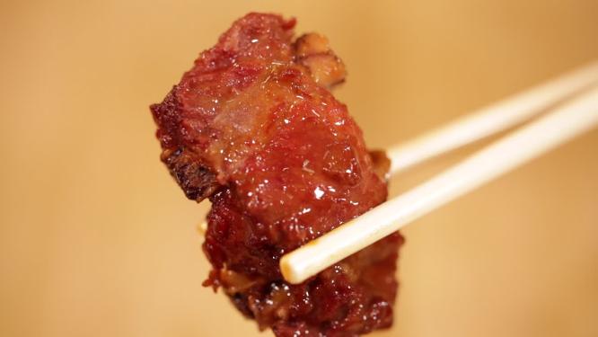 筷子夹起排骨肉特写