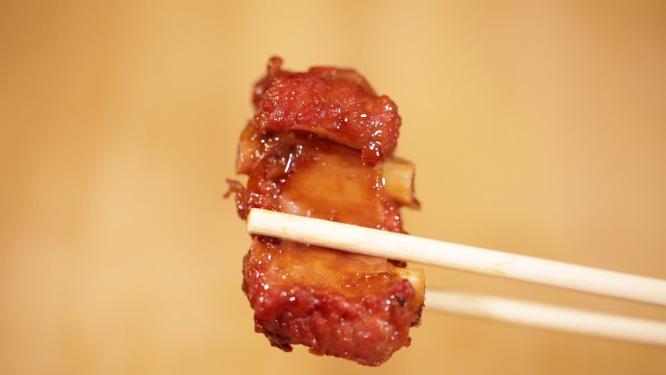 美食特写筷子夹起红烧排骨肉