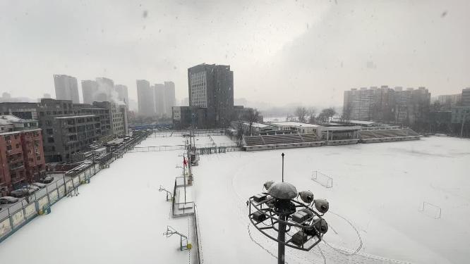 冬季冬天大雪覆盖的操场跑道寒冷锻炼的人
