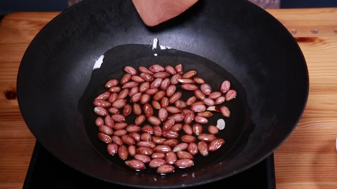 妈妈制作油炸花生米