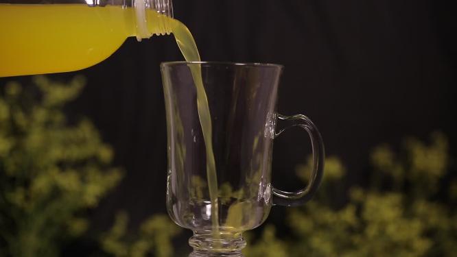 瓶装水果汁倒入高脚玻璃杯喝饮料