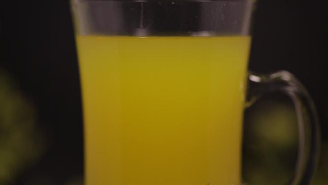 瓶装水果汁倒入高脚玻璃杯喝饮料