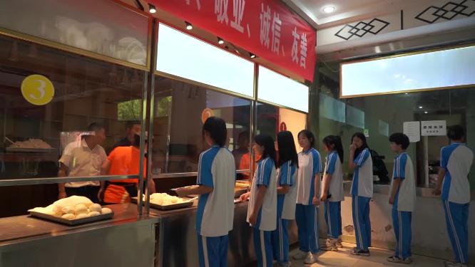 一群中学生学校食堂排队打饭吃午饭