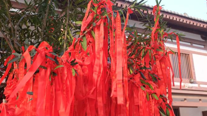寺庙里在微风中飘动的红色祈福带