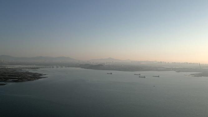 厦门环东海域晨光中的海边和城市建筑航拍