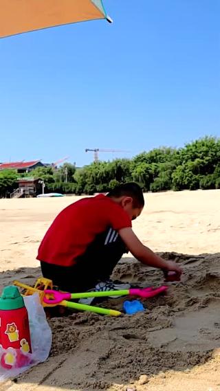 夏天沙滩男孩子玩沙竖版高清