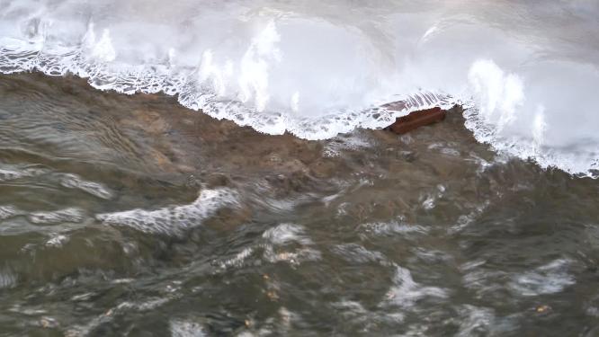 4K北方冬天阳光下河流溪流结冰解冻