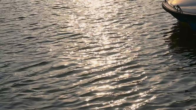 傍晚金色阳光洒在水面上波光粼粼的慢镜头