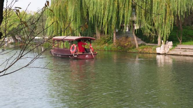 扬州瘦西湖在阴雨天行驶的摇橹船及船娘