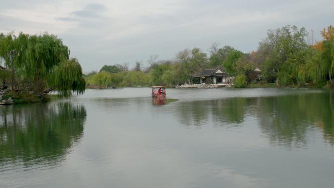 扬州瘦西湖在阴雨天行驶的摇橹船及船娘