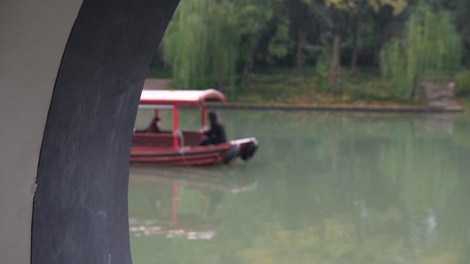 扬州瘦西湖在阴雨天行驶的摇橹船及船娘