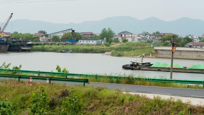 货船航行在小镇河道上实拍空镜