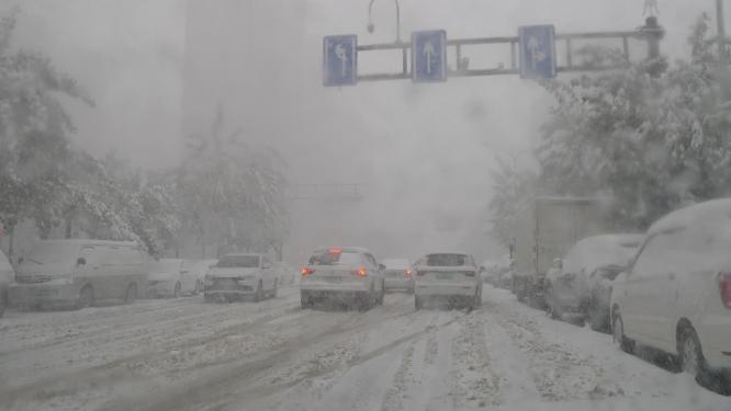 驾驶车辆从前窗4k实时拍摄城市街道雪景 
